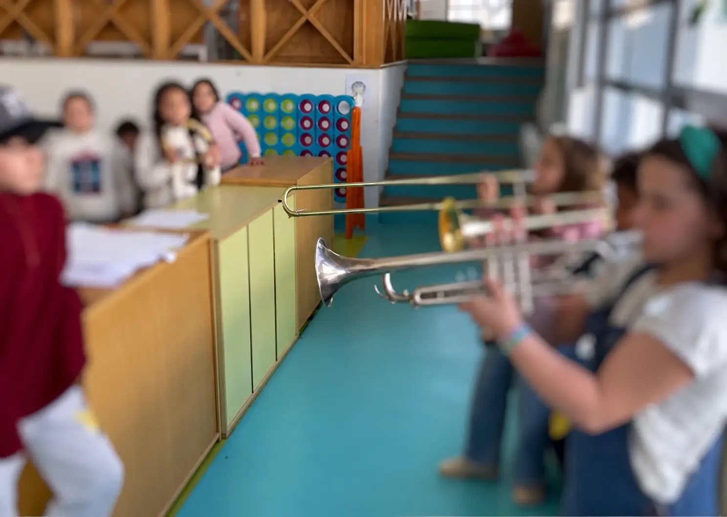 Crianças participam numa atividade de instrumentos de sopro na escola